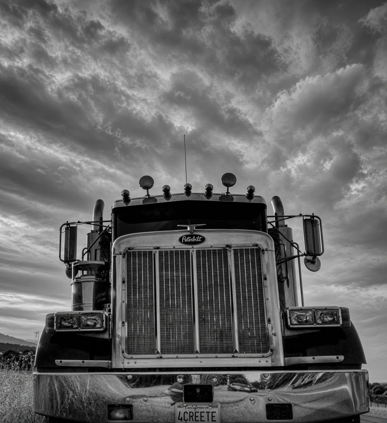 Chrome-grille truck parked roadside at sunset
